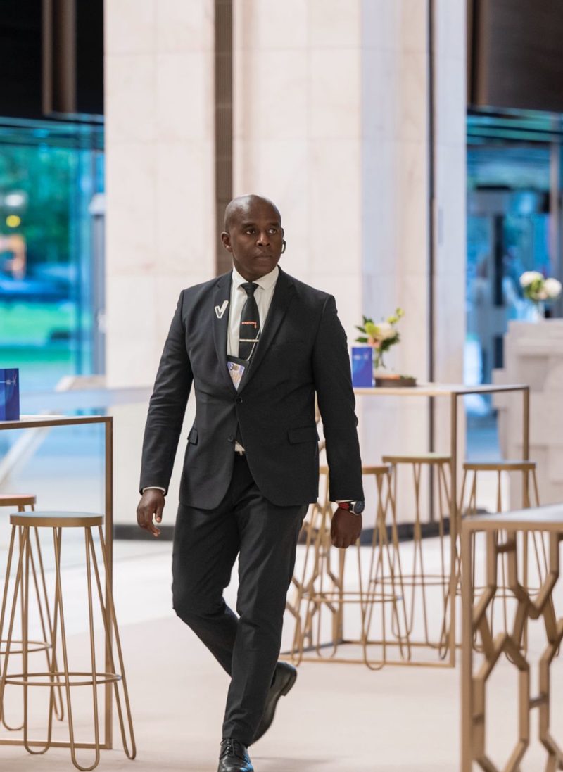 Agent SECURY3 en costume dans un hall